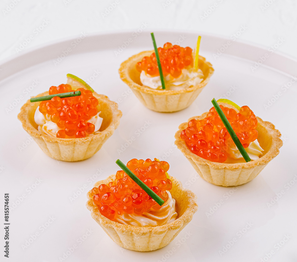 Elegant tartlets with salmon caviar on white plate Elegant tartlets with salmon caviar on white plate