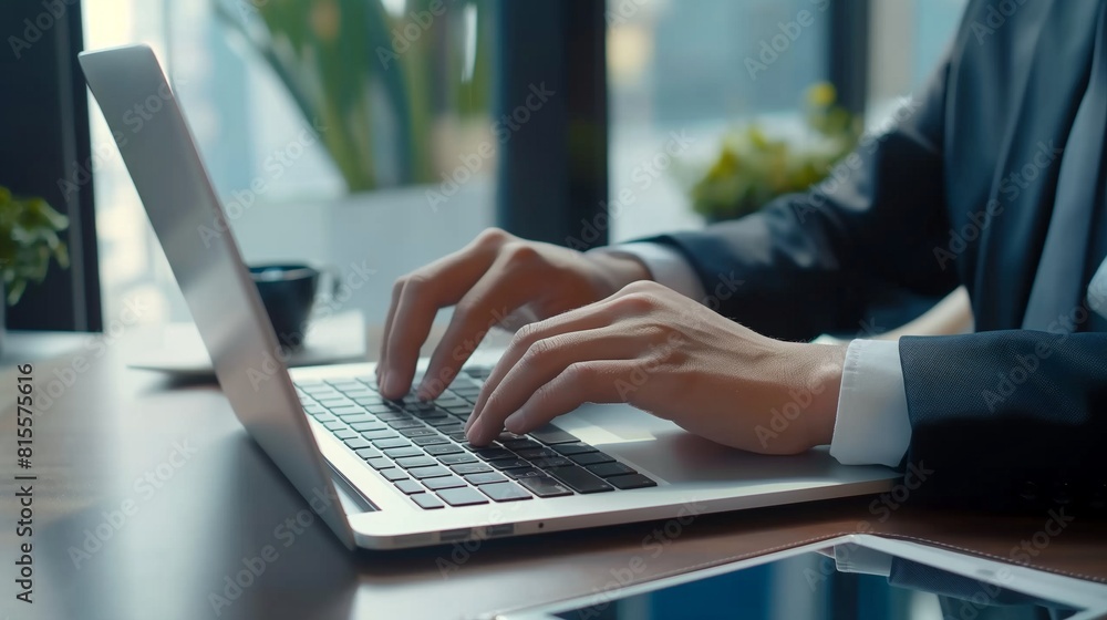 Business man working on laptop computer at modern office. Businessman in black suit working and typing on laptop keyboard, surfing the internet with digital tablet on office table Business man working on laptop computer at modern office. Businessman in black suit working and typing on laptop keyboard, surfing the internet with digital tablet on office table