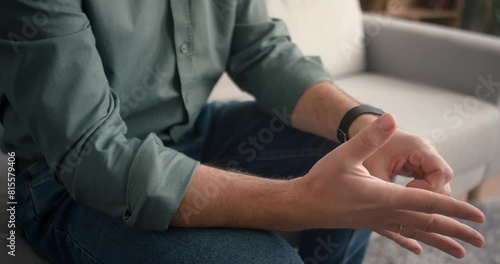 Camera view of Caucasian mans hands. Male playing with his engagement ring. Moving with his hands from being nervous while thinking. Sitting on sofa while talking with someone. Communication concept.