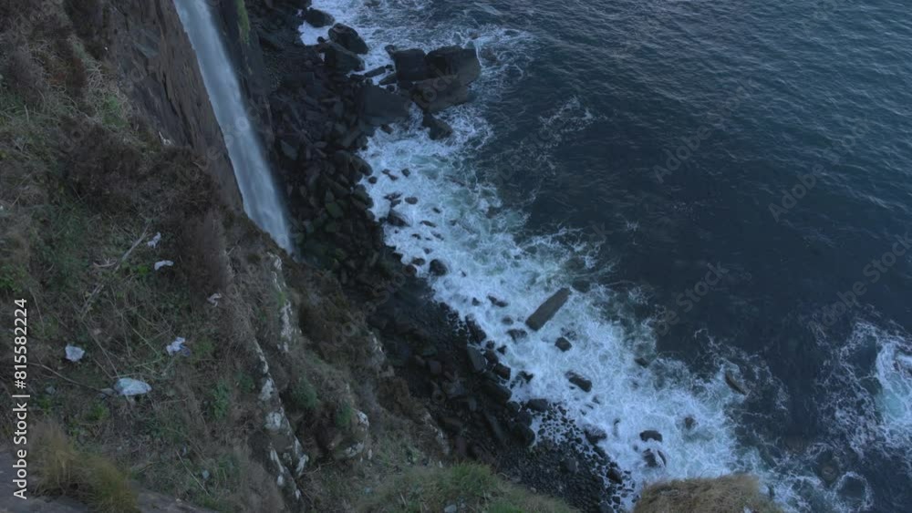 Top-down shot of the waves crashing on the beach below the Mealt Falls Top-down shot of the waves crashing on the beach below the Mealt Falls