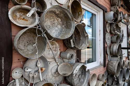 The ‘pan house’ (‘puodu namas’) is covered with pots and pans of all shapes and sizes, closeup view photo