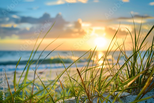 beautiful sunset on the beach with waves and grass in the foreground creating a serene and picturesque scene