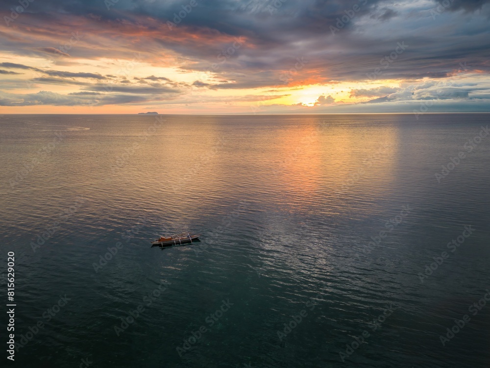 Obraz premium Aerial view of a boat in the sea at sunset at Siquijor, Philippines