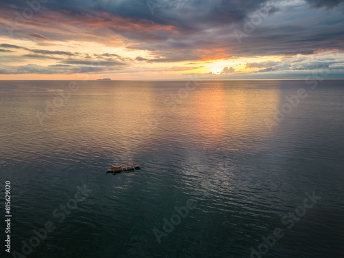 Aerial view of a boat in the sea at sunset at Siquijor, Philippines © Wirestock