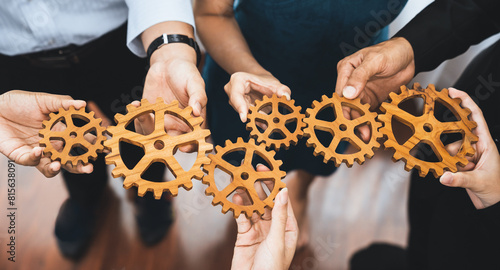 Фотография Office worker holding cog wheel as unity and teamwork in corporate workplace concept