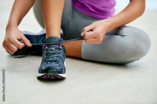 Hands, tie and woman with shoes for exercise fashion or start of fitness routine on floor with feet. Workout, gear or runner prepare sneakers for training in gym with laces and closeup on footwear