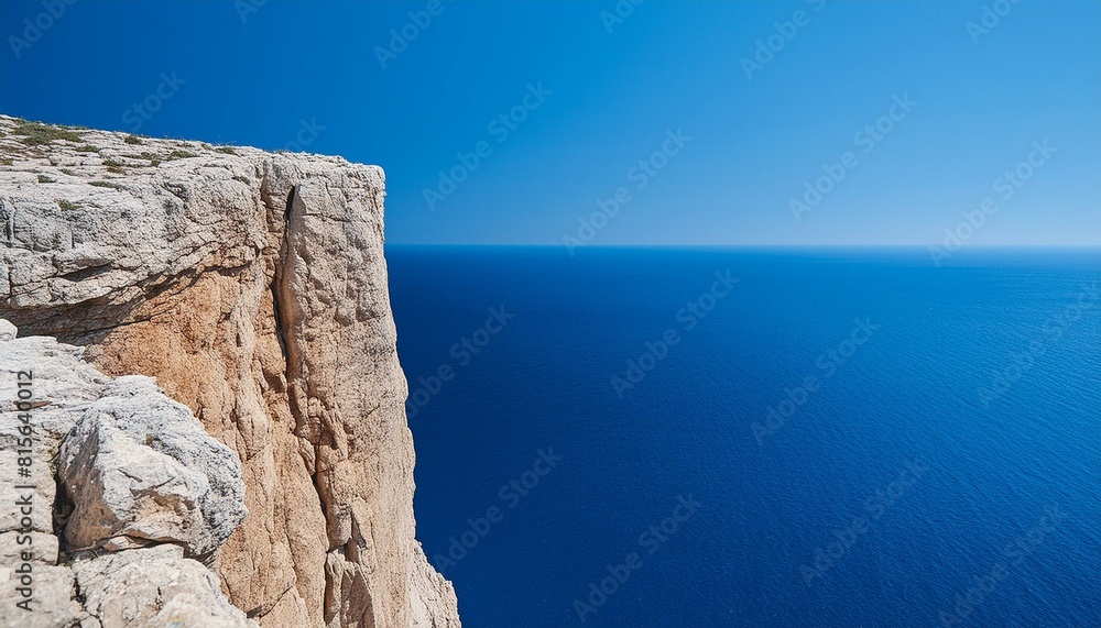 view of the sea from the cliff. A coastal scene with towering cliffs and a deep blue sea under a clear sky. 