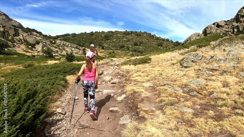 Following girl and woman trekking along a path near Penalara, in Guadarrama mountain range, Madrid, Spain photo