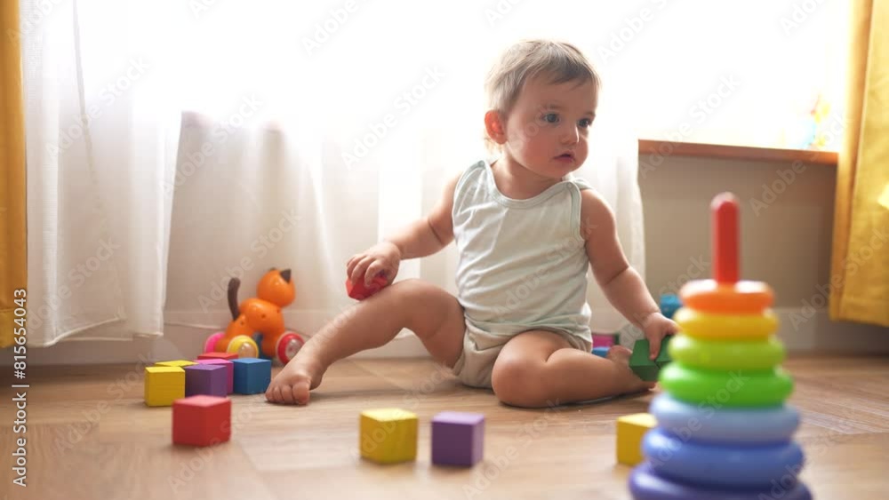 baby plays with toys cubes. kindergarten a teaching children kid dream concept. baby on the lifestyle floor of the house plays with a pyramid and cubes toys development of fine motor skills baby plays with toys cubes. kindergarten a teaching children kid dream concept. baby on the lifestyle floor of the house plays with a pyramid and cubes toys development of fine motor skills