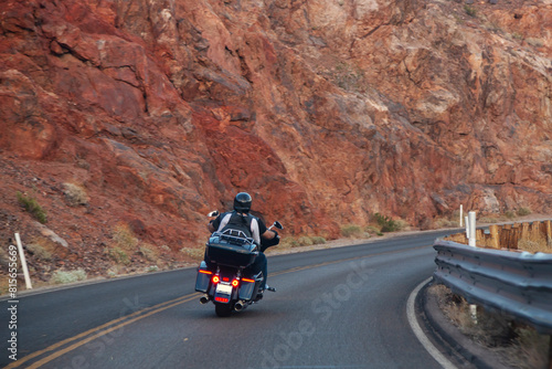 Motorcycle trip across America. Couple of bikers rides along the highway against the backdrop of rocks, rear view. Unrecognizable bikers on a motorcycle