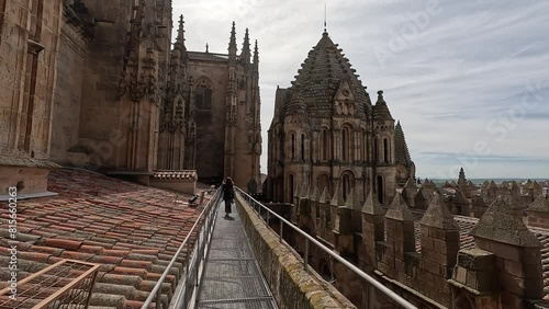 Woman walking along a metal walkway on the roof of the old cathedral of Salamanca, Castilla y Leon, Spain photo