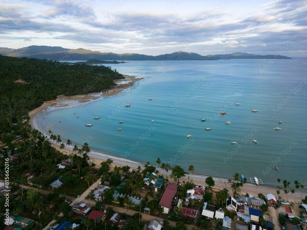 Obraz premium an aerial view of a beach resort in the distance and water surrounding: Port Barton, Philippines