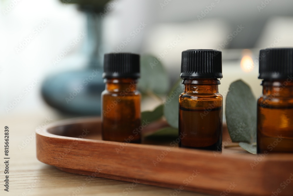 Aromatherapy. Bottles of essential oil and eucalyptus leaves on wooden table, closeup Aromatherapy. Bottles of essential oil and eucalyptus leaves on wooden table, closeup