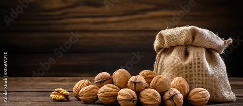 Walnuts in a burlap bag with copy space on a wooden background photo