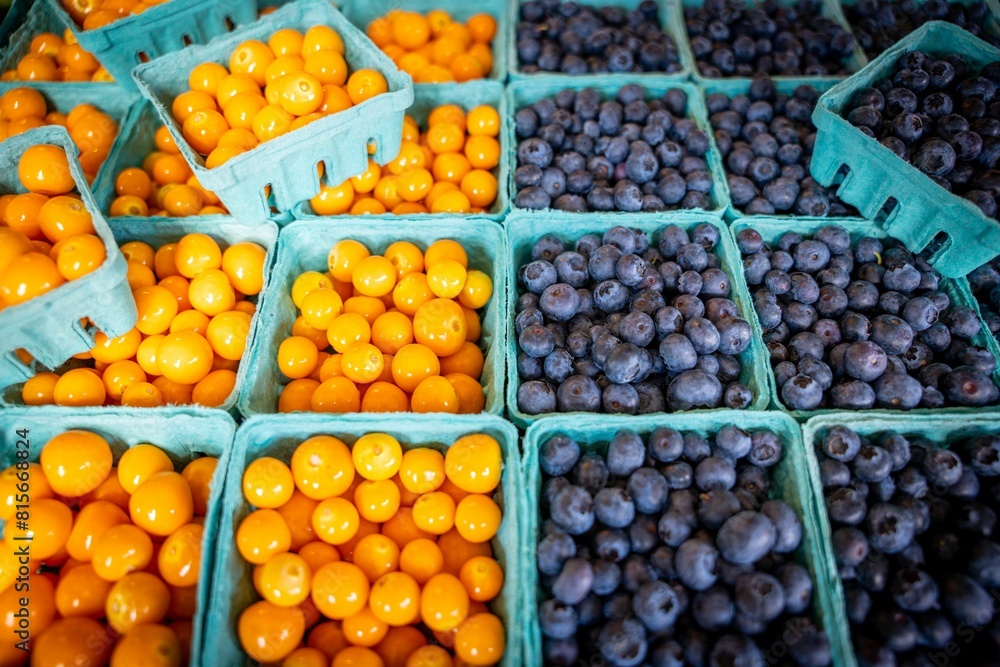 High angle shot of boxes of kumquats and blueberries at a market High angle shot of boxes of kumquats and blueberries at a market