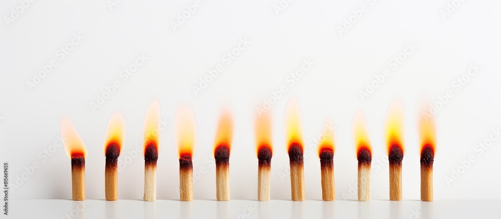 Fototapeta premium A copy space image of a row of three matches one of which is lit burning on a white background