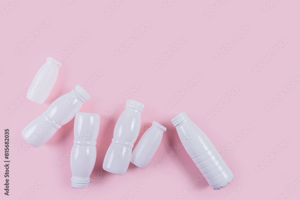 Top view of plastic bottles against a pink background, highlighting the importance of sustainable and reusable packaging Top view of plastic bottles against a pink background, highlighting the importance of sustainable and reusable packaging