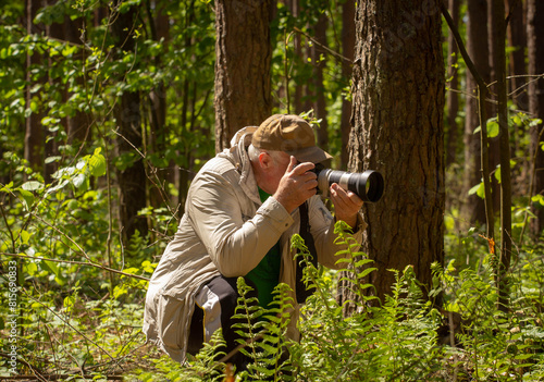 The process of photographing nature in the forest.
The photographer has chosen a subject and is preparing to photograph it.