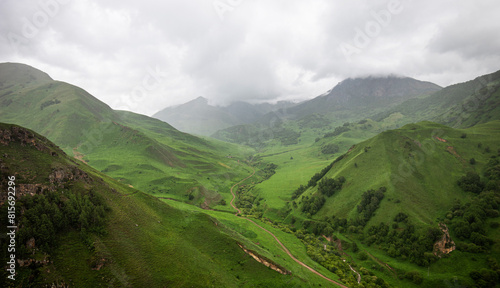 Cloudy and rainy day in spring, low storm clouds.Summer mountain landscape. Amazing view of the valley and lush green pastures in the Caucasus, Georgia. Valley surrounded by high mountain ranges.