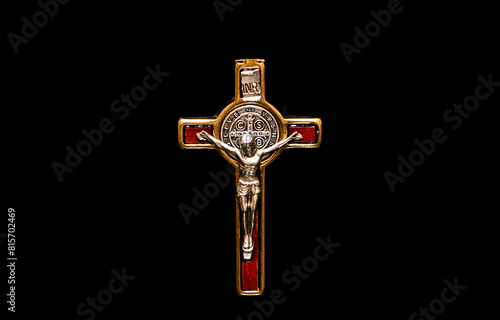 A close up of a metal crucifix on a black background
