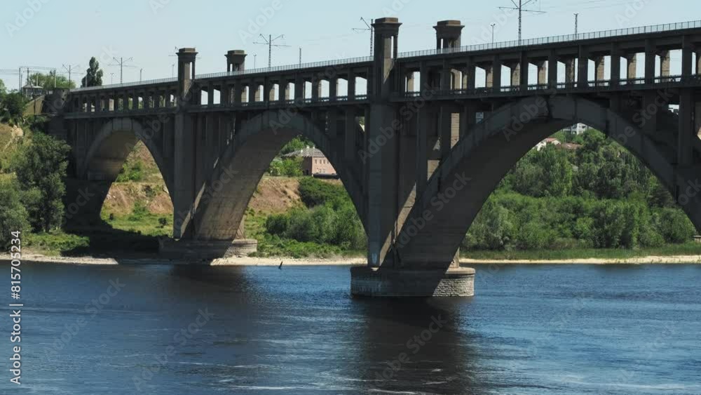 A beautiful reinforced concrete bridge consisting of four arched spans and two transport tiers - Arch Bridge over the river on a summer day. A beautiful reinforced concrete bridge consisting of four arched spans and two transport tiers - Arch Bridge over the river on a summer day.