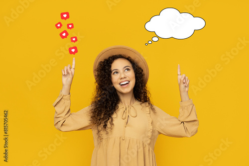 Young woman on yellow background with talk cloud and like hearts