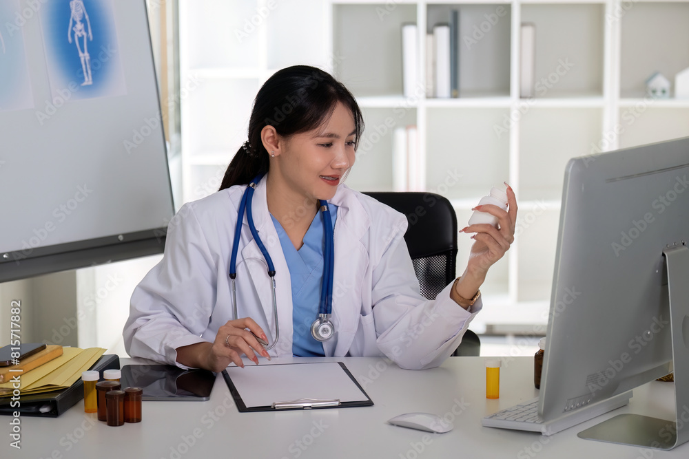 Asian Female Doctor Analyzing Medication Bottle in Clinic Asian Female Doctor Analyzing Medication Bottle in Clinic