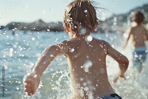 Young children splashing and playing in the water at the beach on a bright sunny day. photo