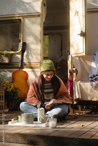 Wallpaper Mural A trendy, hippie-inspired girl relishes a hot beverage on the house terrace, showcasing her style. Torontodigital.ca