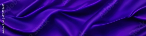 A close-up of purple silk fabric reveals an abstract landscape of rich textures, with the material's glossy finish reflecting a spectrum of muted colors.