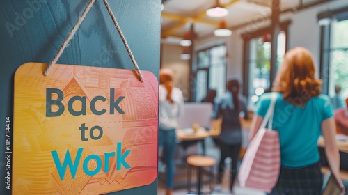 A zoomed-in image of a colorful "Back to Work" sign hanging on the office door, with employees eagerly entering the workspace in the background.