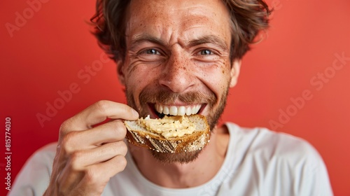 A close frontal view of a Swiss man savoring a bite of bread with creamy hummus  with emphasis on his joyous expression