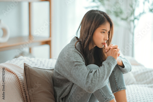 Depressed young woman sitting on couch in the living room at home, Frustrated confused female feels unhappy problem in personal life quarrel break up with boyfriend © oatawa