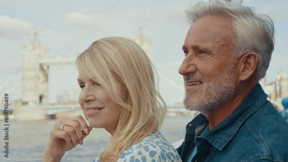Happy senior couple spending time together in London city. Beautiful woman and man hugging while watching the Thames river. Concepts about seniority, lifestyle and travel Happy senior couple spending time together in London city. Beautiful woman and man hugging while watching the Thames river. Concepts about seniority, lifestyle and travel