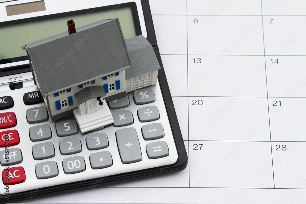 Mortgage payment due with house and calculator on a calendar Mortgage payment due with house and calculator on a calendar