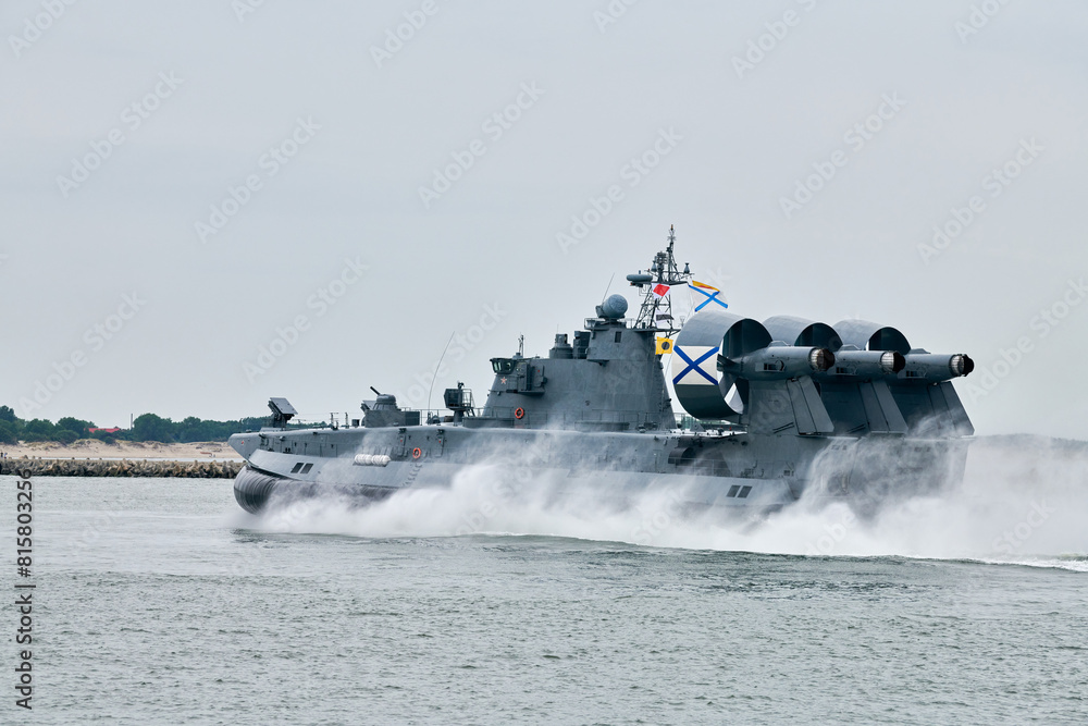 Fototapeta premium Hovercraft warship armed with armament sails into sea toward military target to attack and destroy enemy, military hovercraft ship performing strategic maneuver, Russian sea power deployment