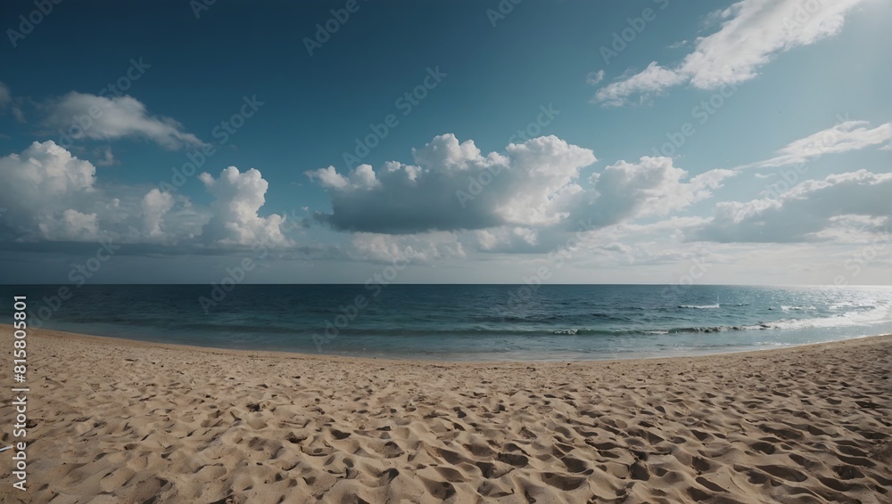 A serene beach with clear blue ocean water and fluffy clouds in the sky.