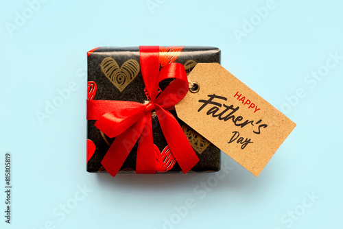 Happy Father's Day. Top view of gift box with red bow and brown sale tag with the text Happy Father's Day