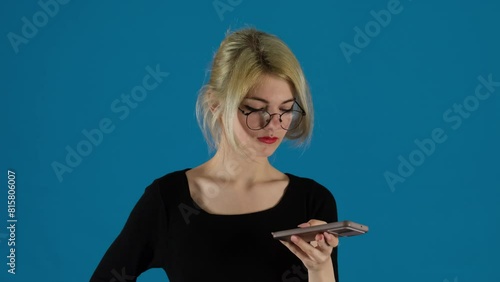 Woman worker presses button on smartphone to record voicemail. Businesswoman gaze fixed on smartphone screen at work in office photo