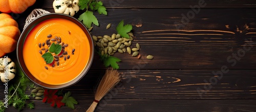 Top view of a vegan copy space image featuring a bowl of pumpkin soup garnished with parsley and pumpkin seeds a perfect dish for Halloween or Thanksgiving day