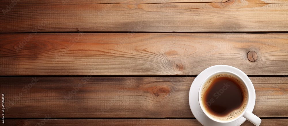 A wooden background features a white cup filled with coffee providing ample copy space for text A wooden background features a white cup filled with coffee providing ample copy space for text