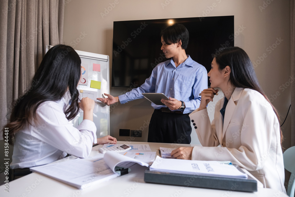Naklejka premium Group of Asian businessmen discuss to plan analysis of company marketing strategy and brainstorm with report documents in office.