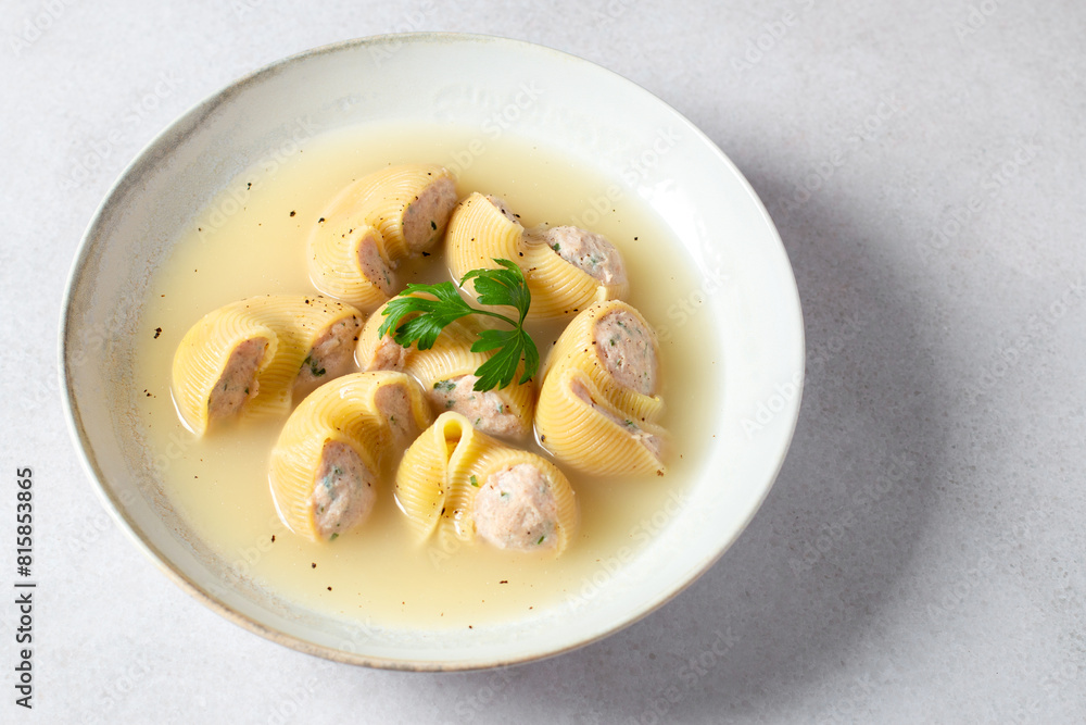 Traditional Catalan Christmas dish Escudella in white plate on table, stuffed pasta in meat broth, top view Traditional Catalan Christmas dish Escudella in white plate on table, stuffed pasta in meat broth, top view