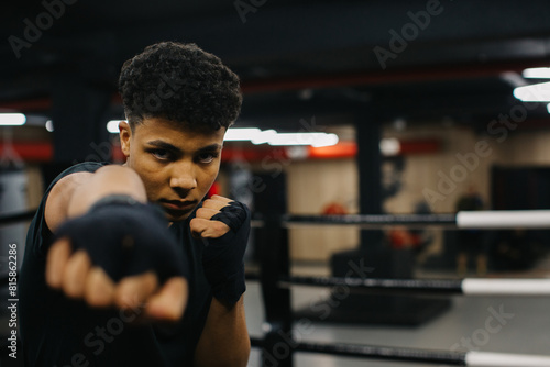 A strong young boxer trains his punches in the gym.