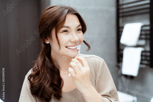 Young Asian Woman Smiling While Brushing Teeth In Stylish Bathroom. Concepts Of Beauty Routine  Happiness  And Self-Care.
