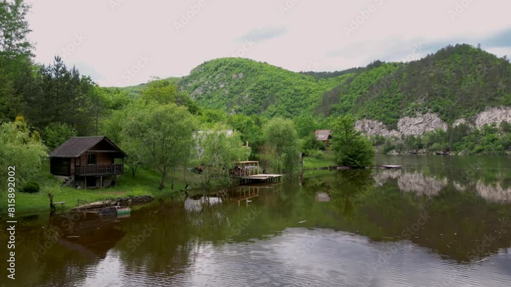 Beautiful 4k aerial drone view of Two senior people riding on boat on Lake and river Drina, beautiful nature, forest, mountain clifs and wooden cabins on green water. Visegrad 11.05.2024 Beautiful 4k aerial drone view of Two senior people riding on boat on Lake and river Drina, beautiful nature, forest, mountain clifs and wooden cabins on green water. Visegrad 11.05.2024