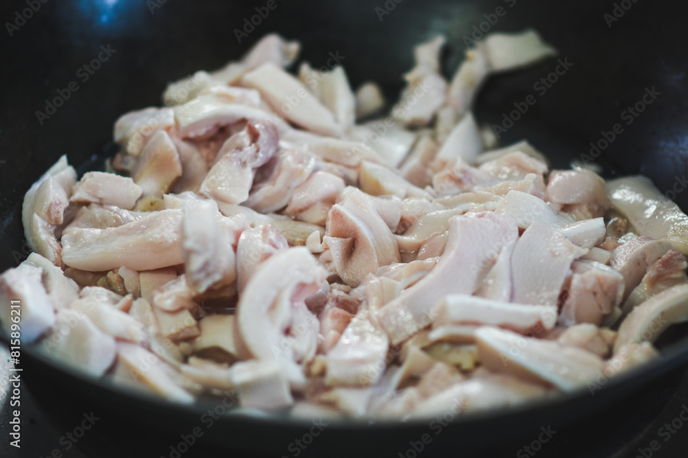 Pork belly is being fried in a pan. Pork belly is being fried in a pan.