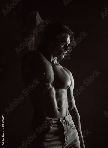 Portrait of sporty handsome muscular man, black and white contrast body texture. Fitness motivation, strengthen muscles, training male gym programs