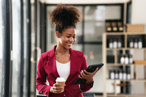 African american businesswoman in suit drinking coffee and reading accounting information of new business