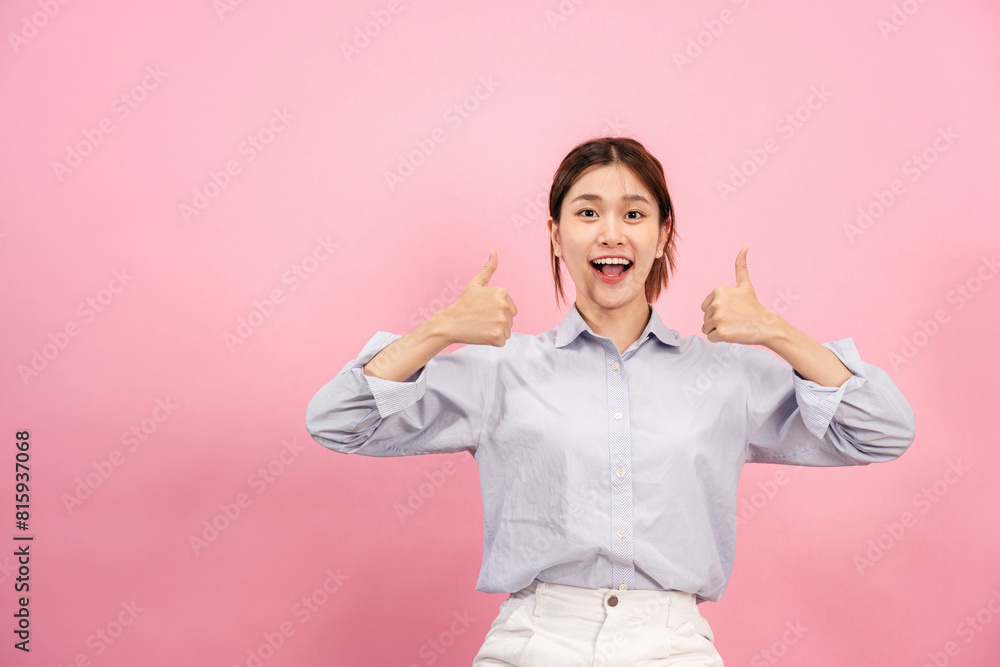 © Katcha - Young asian woman using both hands with fingers to thumbs up gesture with surprised and excited face